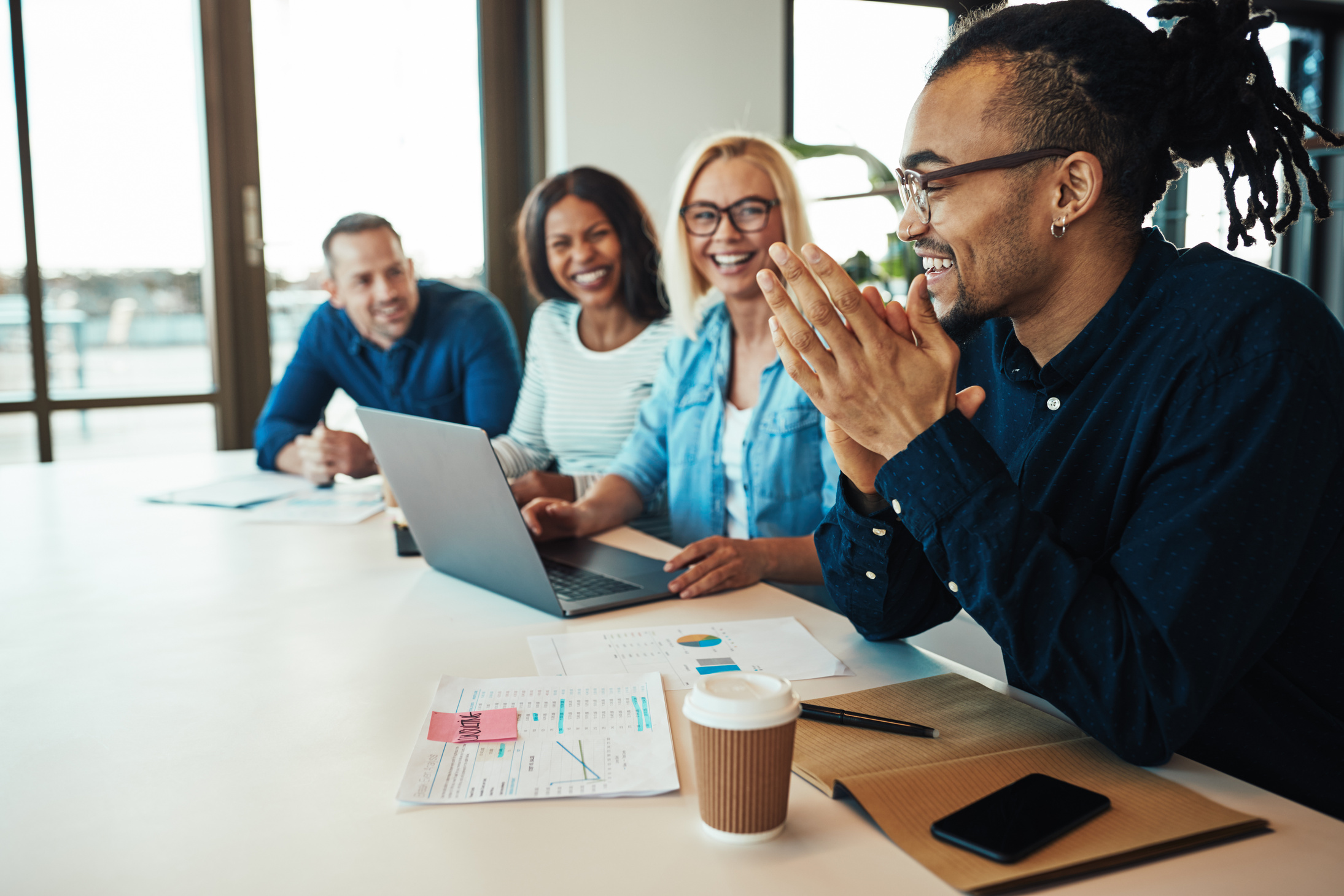 African American Office Worker Laughing with Colleagues in a Mee